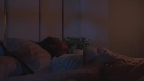 Sleepless man tossing and turning in bed during the night Vídeo Stock 339514696