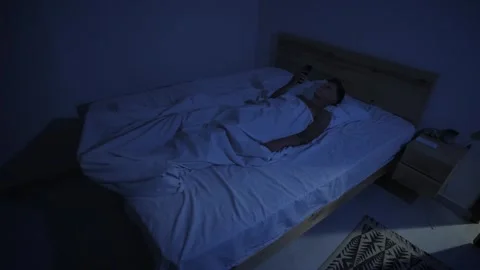 Sleepless man using smartphone in bed at night, excessive screen time and social Stock Footage 346243829