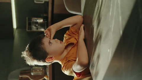Sleepy child at table waiting for breakfast. Early morning at home. Tired and Stock Footage 258493349