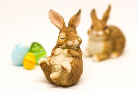 Sleepy easter bunny with friend and glass eggs isolated Stock Photos