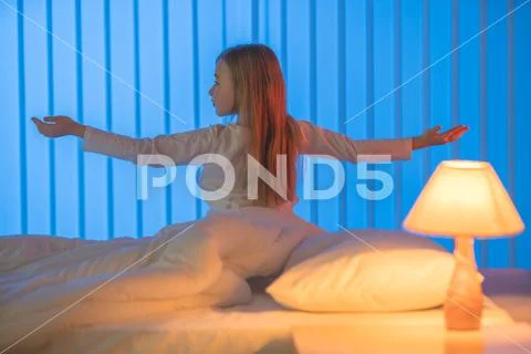 The sleepy girl gesture in the bed. Evening night time Stock Photos