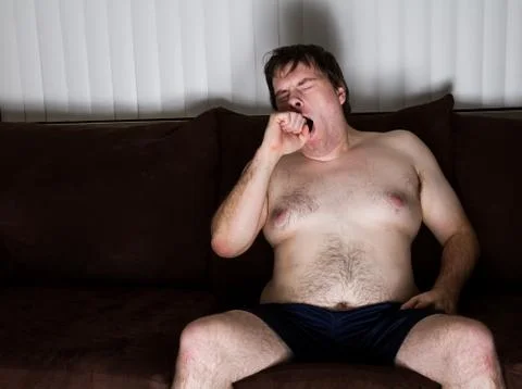 Sleepy guy sitting on the couch Stock-Fotos
