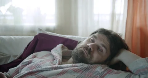 Sleepy lazy man on the couch napping, falling asleep. Insomnia, sleep problem Video stock 238467183
