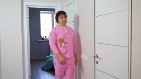 Sleepy man walks through apartment staggering after party Stock Footage 274686483