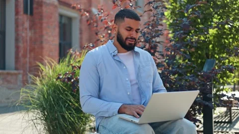 Sleepy man yawning while sitting outdoors due to overwork on personal laptop Video stock 250391031