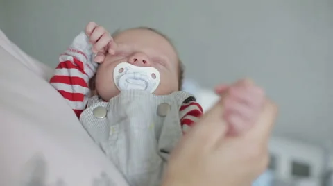 A sleepy newborn boy being held by an adult Stock Footage 67599397