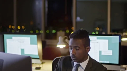 Sleepy Office Worker Typing on Computer at Night Stock Footage