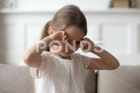 Sleepy tired upset little child crying rubbing eyes feel hurt Stock Photos