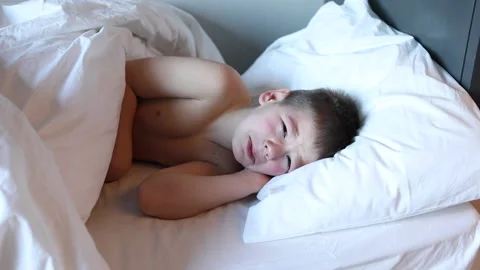 Sleepy toddler boy lying in bed and crying. Tired child in bedroom. Stock Footage 172011095