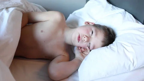 Sleepy toddler boy lying in bed and crying. Tired child in bedroom. Stock Footage 172011568