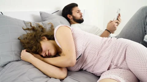Sleepy woman and man using tablet in bed slow motion Stock Footage 59189121