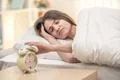 The sleepy woman turn off the alarm Photo