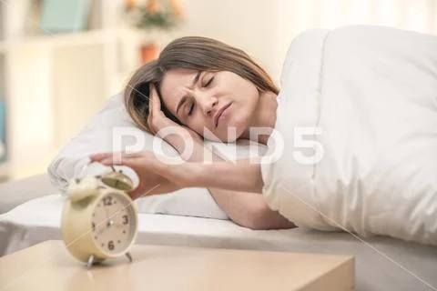 The sleepy woman turn off the alarm Stock Photos