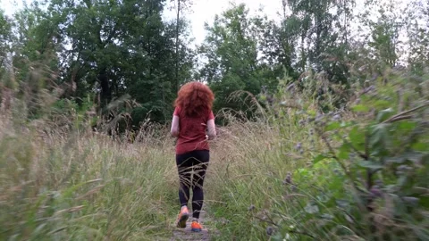 Slender and athletic middle-aged red-haired woman is engaged in running outdo Stock Footage 135089240