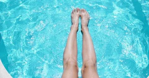 Slender female legs in blue water in the pool. Happy woman doing leg workout in Stock-Footage 141374553