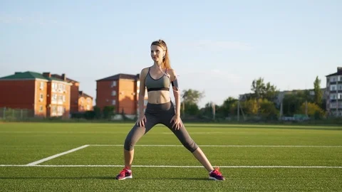 Slender female runner is preparing to run in the morning to the music. A runner  Stock Footage 115640348