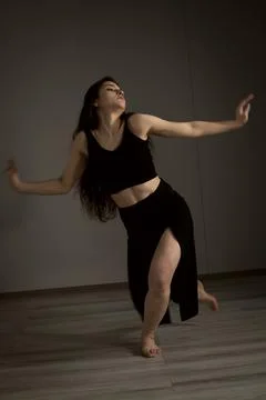 Slender flexible dance performer during a dance practice in modern studio Stock Photos