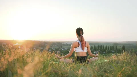 Slender girl doing yoga in the field at sunset.  Stock Footage 87837853