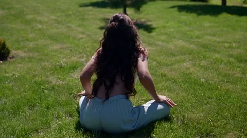 Slender girl performs a breathing exercise while practicing yoga on the street Stock-Footage 155483503