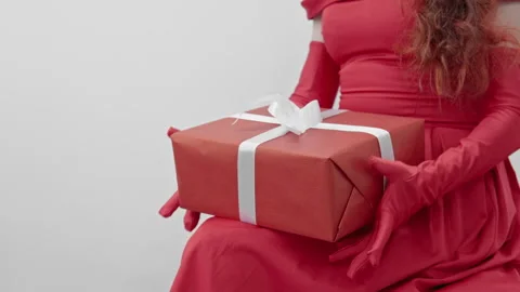 A slender hand in red gloves easily holds a gift bag, symbolizing joy and Stock Footage 246423527