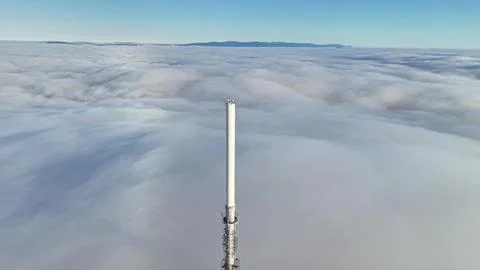 Slender Pole Extending Through Cloudy Skies, Delicate Mast Rising Amidst Va.. Foto stock
