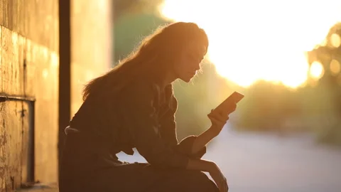 Slender young girl posing in a back-light. Silhouy of a slender girl. Video stock 91151217