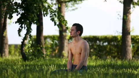 Slender young man practicing yoga in park. Vídeo Stock 79144052