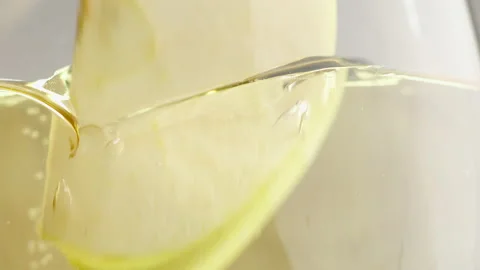 A slice of apple falls into a glass of cider. Stock Footage 147347246