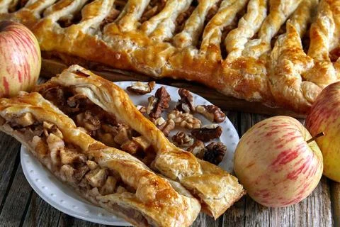 A slice of apple pie with walnuts strudel lies on a dessert plate Stock Photos