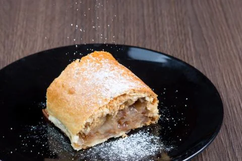 Slice of apple strudel on a black plate Stock Photos