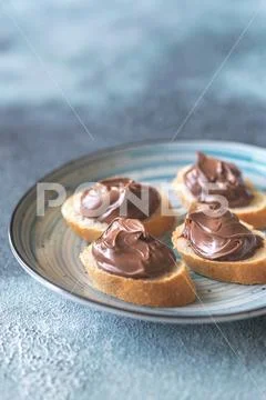 Slice of baguette with chocolate cream on the saucer Stock Photos