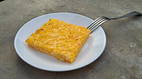 Slice of baked pumpkin omelette with fork, side view Stock Photos