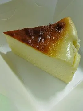 Slice of Basque Burnt Cheesecake inside White Takeout Box Stock Photos
