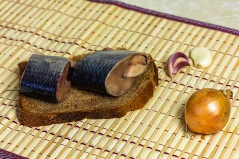 On a slice of black bread are pieces of herring close-up Stock Photos