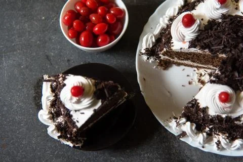 A slice of Black forest cake and cherries Stock Photos