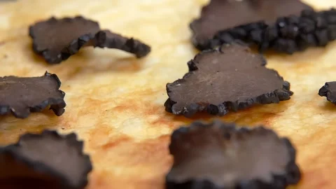 A slice of black truffle falls on an omelette 스톡 동영상 264758221