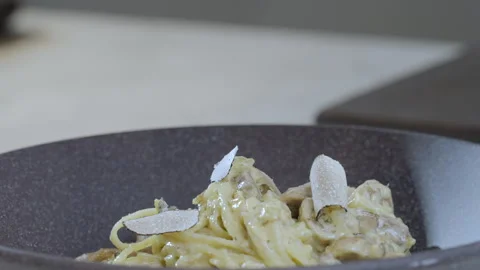 Slice of a black truffle falls on the spagetti pasta. Slow motion 4k video. Stock Footage 273238148