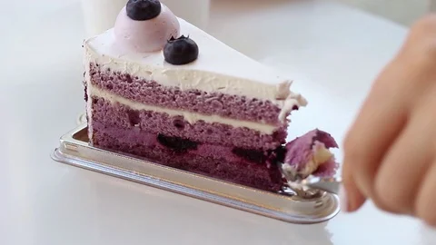 Slice of blueberry cake and female hand on white table. Stock Footage 123322158