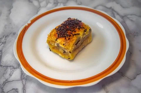 Slice of bolen pastry with fruit chunks and chocolate sprinkles on ceramic .. Foto stock