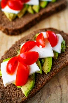 Slice of bread with avocado and tomato. Stock Photos