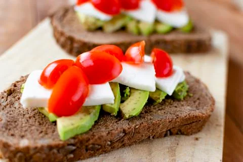Slice of bread with avocado and tomato. Stock Photos