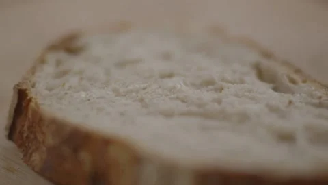 Slice of bread being placed onto wooden surface Stock Footage 194478422