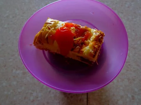 A slice of bread for breakfast topped with cheese and sauce Foto stock