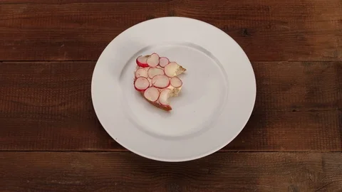 Slice of bread with butter and radish disappears- top view stop motion animation 스톡 동영상 73312042