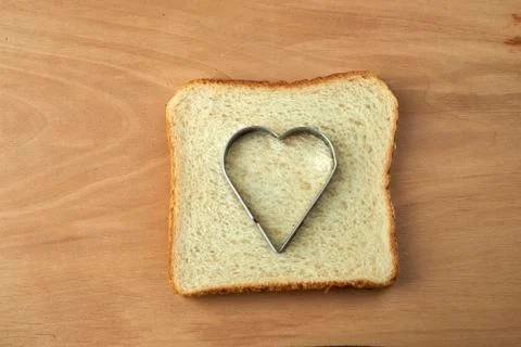 Slice of bread with cut out heart shape Stock Photos