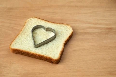 Slice of bread with cut out heart shape Stock Photos