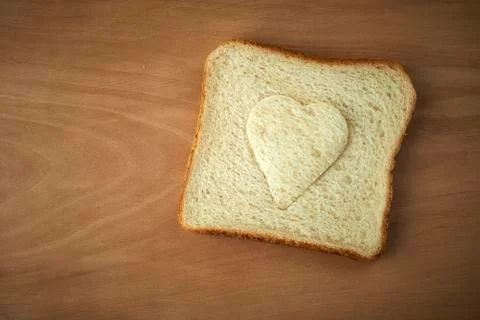 Slice of bread with cut out heart shape Stock Photos
