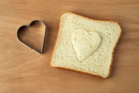 Slice of bread with cut out heart shape Stock Photos