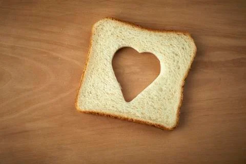 Slice of bread with cut out heart shape Stock Photos
