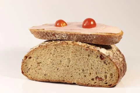 A slice of bread with ham and tomato on half of bread Stock Photos